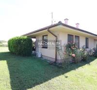 Ein Einfamilienhaus in Cabaj - Čápor mit Garten, Fenstern, Rosen und einer steinigen Umgebungsgestaltung.