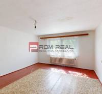 Ein Zimmer mit weißen Wänden und Holzboden in einem Einfamilienhaus.