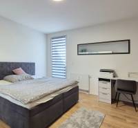 Schlafzimmer in einer 4-Zimmer-Wohnung mit Doppelbett, Schreibtisch und Fenster mit Rollladen.