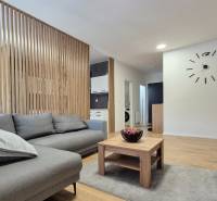 Ein stilvolles Wohnzimmer in einer 4-Zimmer-Wohnung mit Holzverkleidung, einem bequemen Sofa und einem Tisch.