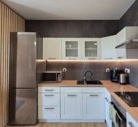 Küche mit Geräten und Holzelementen in einer 4-Zimmer-Wohnung.