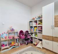 Kinderzimmer mit Spielzeug und Schrank in einer 4-Zimmer-Wohnung, heller Raum.
