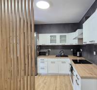 Küche mit hellen Möbeln in einer 4-Zimmer-Wohnung, Holzelemente, moderne Geräte.