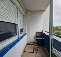 Balkon mit Außensitzbereich in einer 2-Zimmer-Wohnung. Rollos an den Fenstern.