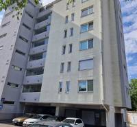 Wohngebäude an der Vrakunská-Straße in Bratislava - Ružinov mit einem Parkplatz vor dem Gebäude.
