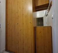 Ein Einbauschrank aus Holz mit weißen Fliesen auf dem Boden in einer 2-Zimmer-Wohnung.
