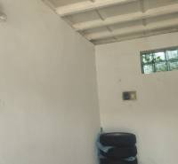 Weiße Wände, Reifen, Glühbirne, Schalter und kleines Fenster in der Garage.