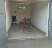 Offene Garage in Nová Dubnica in der Topoľová-Straße mit verschiedenen Gegenständen und Betonboden.