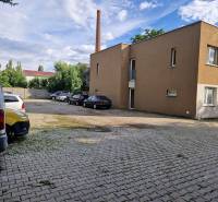 Parkplatz in der Tehelna-Straße in Pezinok mit Autos und einem Gebäude, Platz für eine Einzimmerwohnung.
