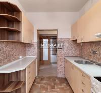 Küche in einer 3-Zimmer-Wohnung mit Holzschränken und Fliesenverkleidung.