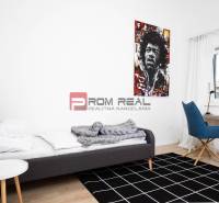 Schlafzimmer in einer 3-Zimmer-Wohnung mit Bett, Sessel und Bild an der Wand.