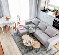 Küche und Wohnzimmer in einer 3-Zimmer-Wohnung mit Esstisch und Sofa.