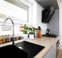 Küche in einer 3-Zimmer-Wohnung mit eingebautem Kochfeld und Pflanzen auf der Fensterbank.