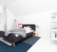 Schlafzimmer in einer 3-Zimmer-Wohnung mit modernem Bett, Regal und weißen Wänden.