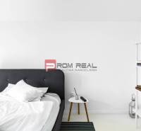 Schlafzimmer mit Bett und Regal mit Büchern in einer 3-Zimmer-Wohnung.