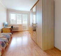 Ein Zimmer mit hellem Boden, Bett, Kleiderschrank und Fenster in einer 3-Zimmer-Wohnung.