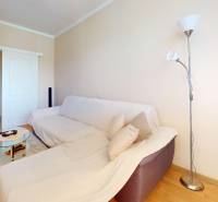 Wohnzimmer in einer 3-Zimmer-Wohnung mit Sofa, Tisch und Stehlampe.