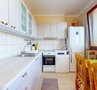 Küche in einer 3-Zimmer-Wohnung mit Küchenzeile, Kühlschrank, Esstisch und großem Fenster.