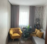 Gemütliches Zimmer in einer 2-Zimmer-Wohnung mit Sessel, Sofa und Pflanzen.