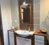 Waschbecken mit Spiegel im Badezimmer einer 2-Zimmer-Wohnung, Keramikfliesen mit Ornamenten.