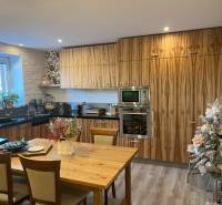Küche in einer 2-Zimmer-Wohnung mit Holzschränken, Tisch und Weihnachtsdekoration.