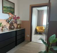 Im Flur der 2-Zimmer-Wohnung befinden sich ein Schrank, Dekorationen und ein gelber Sessel.