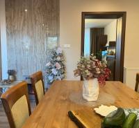 Esstisch mit Blumen, geschmückter Baum und Küche in einer 2-Zimmer-Wohnung.