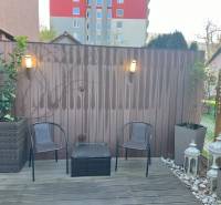 Terrasse in Ružinov mit Holzboden, Stühlen, Leuchten und dekorativen Laternen.