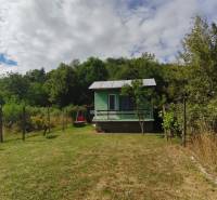 Ein Ferienhaus in der Strhárska-Straße in Modrý Kameň, umgeben von Grün und einem eingezäunten Garten.