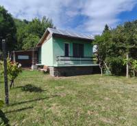 Das Haus in der Strhárska-Straße in Modrý Kameň ist von einem grünen Rasen und Bäumen umgeben.