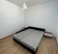 Schlafzimmer in einer 3-Zimmer-Wohnung mit Bett, Nachttischen und hängender Leuchte.