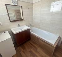 Badezimmer in einer 3-Zimmer-Wohnung mit Badewanne, Waschbecken und Waschmaschine.