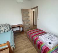 Ein Zimmer mit zwei Betten und einem Tisch in einer 3-Zimmer-Wohnung.