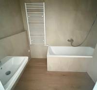 Badezimmer mit Badewanne und Handtuchheizkörper in einer 3-Zimmer-Wohnung, dunkler Boden.