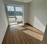Ein Zimmer in einer 3-Zimmer-Wohnung mit Laminatboden und einem großen Fenster.