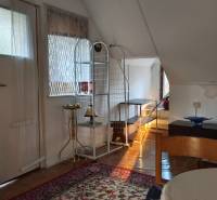 Das Innere der Hütte mit Bett, Tisch, Holz, Teppich und dekorativer Lampe.