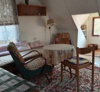 In der gemütlichen Hütte gibt es Stühle, einfache Sessel und einen Tisch auf dem Teppich.