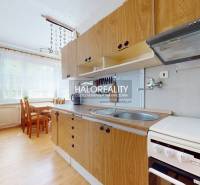 Küche mit Esstisch und Geräten in einer 4-Zimmer-Wohnung.