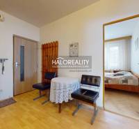 Flur einer 4-Zimmer-Wohnung mit Holzmöbeln, Tisch und Eingang zum Schlafzimmer.