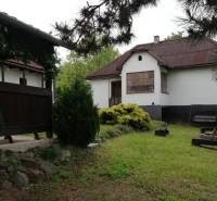 Ein Einfamilienhaus, umgeben von einem Garten, einer Terrasse und einer Feuerstelle, schafft eine angenehme Wohnumgebung.