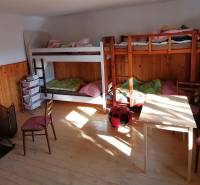 Etagenbetten, Kaminofen und Möbel im Zimmer eines Einfamilienhauses.