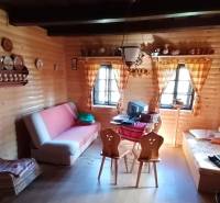 Innenraum eines Einfamilienhauses mit Holzverkleidung, Sofa und traditionellem Möbel.