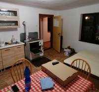 Küche mit Herd, Esstisch und Bett, geeignet für ein Einfamilienhaus.