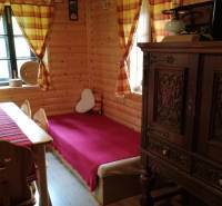 Das Innere der Blockhütte mit massiven Möbeln, Holzwänden und bunten Vorhängen in einem Einfamilienhaus.