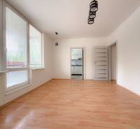 Ein geräumiges Zimmer in einer 3-Zimmer-Wohnung mit Holzboden und großen Fenstern.