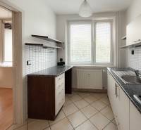 Küche in einer 3-Zimmer-Wohnung mit hellem Fliesenbelag und Möbeln.