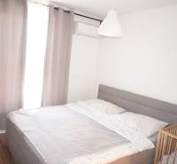 Schlafzimmer im Einfamilienhaus mit großem Bett, Klimaanlage und Kinderbett.