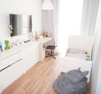 Kinderzimmer in einem Einfamilienhaus mit weißen Möbeln und Holzboden.