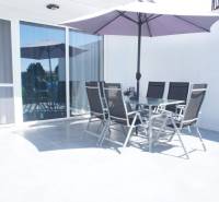 Eine Terrasse mit Sitzgelegenheiten und Sonnenschirm in einem Einfamilienhaus in der Platanová-Straße in Miloslavov.