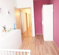Kinderzimmer in einem Einfamilienhaus mit Holzboden und lila Wand.